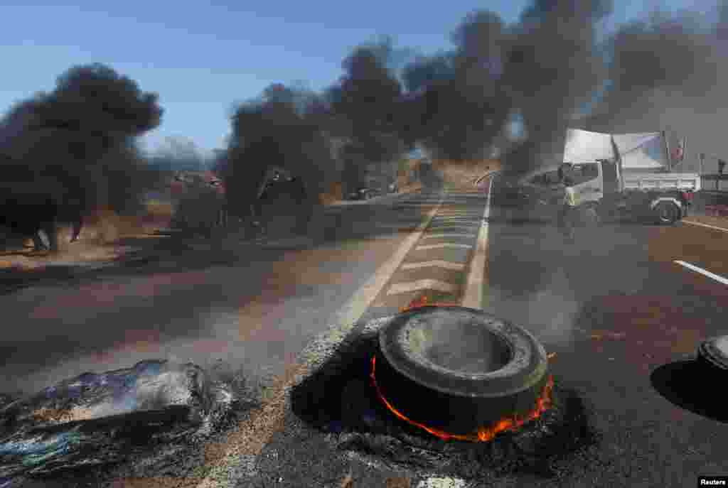 Manifestantes bloquean una carretera con llantas en llamas mientras participan en una manifestación contra la migración ilegal y la delincuencia en Iquique, Chile.