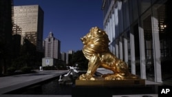 坐落在广州的富力中心外的金色雄狮雕像。 