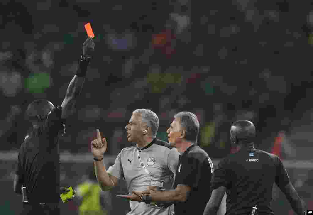 Egypt's head coach Carlos Queiroz, second right, is shown a red card by referee Gassama Bakary Papa of Gambia, Feb. 3, 2022.