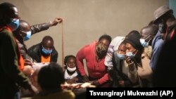 Mawakala wa vyama vya siasa wanafuatilia kwa makini wakati afisa wa uchaguzi akionyesha karatasi ya kura mchakato wa kuhisabu kura ulipoanza katika kituo cha kupiga kura Lusaka, Zambia, Alhamisi Agosti 12, 2021AP Photo/Tsvangirayi Mukwazhi).