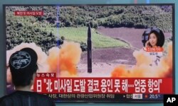 FILE - A woman watches a TV screen showing file footage of a missile launch by North Korea, at a railway station in Seoul, South Korea, Sept. 15, 2017. According to a public opinion survey conducted last month, over 60 percent of South Koreans would be in favor of their country acquiring its own nuclear deterrent.