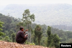 FILE - A man smokes before a commemoration ceremony in Koh Kong province May 11, 2012.