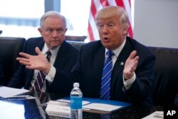 FILE - Then-Senator Jeff Sessions listens at left as Republican presidential candidate Donald Trump speaks with advisers at Trump Tower in New York, Oct. 7, 2016.