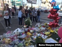 Route 91 Festival goers, tourists and residents of Las Vegas placed candles, flowers, banners and photos of their loved ones at the shrine on the median just across the street from shooting site at the country music festival.