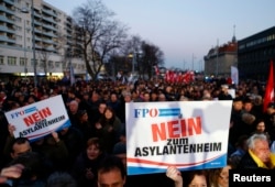 FILE - Protesters carry banners reading 'No refugee home' during an Austrian Freedom Party (FPOe) demonstration in Vienna, March 14, 2016.