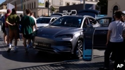 FILE - Visitors watch a BYD car at the IAA motor show in Munich, Germany, on Sept. 8, 2023. The European Union has launched an investigation into Beijing’s support for its EV industry, adding to tensions between the West and China. (AP Photo/Matthias Schrader, File)