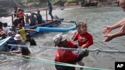 A rescuer carries a child after a boat carrying asylum seekers sank off Java island, in Cianjur, West Java, Indonesia, July 24, 2013.