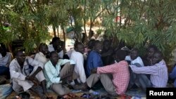 Internally displaced men sit inside a United Nations Missions in Sudan (UNMIS) compound in Juba December 19, 2013. South Sudanese government troops battled to regain control of a flashpoint town and sent forces to quell fighting in a vital oil producing a