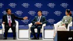 លោក​នាយក​រដ្ឋមន្រ្តី ហ៊ុន សែន (ឆ្វេង) និយាយ​អំពី​ទស្សនៈ​វិស័យ​របស់​លោក​នៅក្នុង​វេទិកា​ពិភពលោក​ស្តីពី​អាស៊ាន លោក​នាយក​រដ្ឋមន្រ្តី​ឡាវThongloun Sisoulith (កណ្តាល) និង​លោកស្រី Aung San Suu Kyi (ស្តាំ) នៅ​ឯ​ វេទិកា​សេដ្ឋកិច្ច​ពិភពលោក​ស្តីពី​អាស៊ាន ដែល​មាន​អ្នក​ចូលរួម​រាប់រយ​នាក់ ដែល​ផ្តោត​លើ​អាស៊ាន​ជំនាន់​ទី៤៖សហគ្រិនភាព និង​បដិវត្តន៍​ឧហ្សាហកម្ម​ជំនាន់​ទី៤។ (AP Photo/Bullit Marquez)