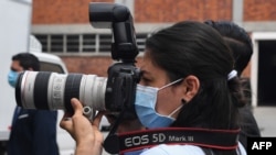 Una fotoperiodista usa una máscara quirúrgica durante una conferencia de prensa en San Salvador, el 21 de abril de 2020.