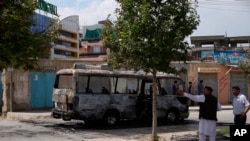 Personal de seguridad inspecciona el lugar de una explosión en un autobús en Kabul, Afganistán, el lunes 3 de junio de 2019.