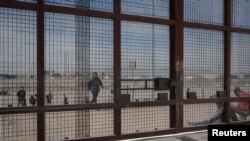 Sejumlah migran bergerak menuju area dinding pembatasan di wilayah perbatasan AS-Meksiko di El Paso, Texas, pada 20 Maret 2024. (Foto: Reuters/Justin Hamel)