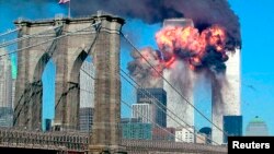 ورلڈ ٹریڈ سینٹر کے دونوں ٹاور یک بعد دیگرے طیارے ٹکرانے کے بعد شعلوں کی لپیٹ میں ہیں۔ 11 ستمبر 2001