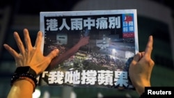 一名蘋果日報的支持者手拿一份最後一期的蘋果日報。（2021年6月24日）