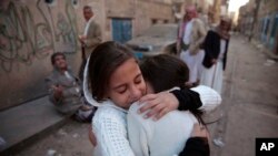 Wasichana wakifarijiana baada ya nyumba yao kupigwa mabomu karibu na Wizara ya Ulinzi ya Yemen na majeshi ya ushirika yanayoongozwa na Saudi Arabia Sanaa, Yemen, Nov. 11, 2017.