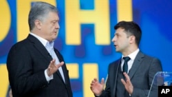 Ukrainian President Petro Poroshenko, left, and Ukrainian presidential candidate and popular comedian Volodymyr Zelenskiy, right, argue during their debates at the Olympic stadium in Kiev, Ukraine, April 19, 2019. 