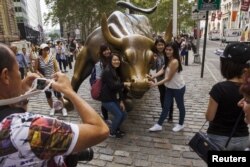 中國遊客在紐約華爾街的銅牛前合影。 （2015年8月24日）