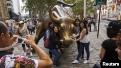 資料照：中國遊客在紐約華爾街的銅牛前合影。（2015年8月24日）