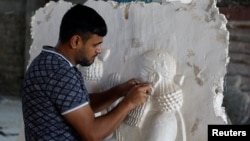 The sculptor Khaled al-Abadi works inside his workshop on his sculptures which depict scenes from the history of the city of Mosul, in Mosul, Iraq, September 15, 2022. (REUTERS/Khalid al-Mousily)