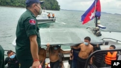 Chinese nationals get off from a speedboat after being rescued from a ship sinking, at an island in Preah Sihanouk Province, southwestern Cambodia on Thursday, Sept. 22, 2022. (Preah Sihanouk province Authority Police via AP) 