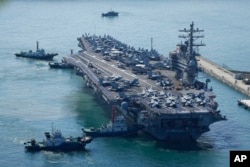 The U.S. carrier USS Ronald Reagan is escorted as it arrives in Busan, South Korea, Friday, Sept. 23, 2022. The nuclear-powered aircraft carrier arrived in Busan port on Friday ahead of the two countries' joint military exercise that aims to show their strength against growing North Korean threats.