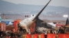 Bombeiros e membros da equipa de resgate trabalham junto aos destroços de um avião de passageiros no Aeroporto Internacional de Muan, em Muan, Coreia do Sul, a 29 de dezembro de 2024.