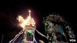 ម៉ូតូស៊ីរ៉ែនបើកផ្លូវពីរគ្រឿង ចតចោលក្បែរមេរុដែលកំពុងខ្មួលខ្មាញ់ដោយផ្សែងនៃការរំលាយរូបសព លោក នួន ជា ក្នុងបរិវេណវត្តព្រំគីរីមរកត ភូមិផ្សារព្រំ ឃុំស្ទឹងកាច់ ស្រុកសាលាក្រៅ ខេត្តប៉ៃលិន កាលពីថ្ងៃទី០៩ ខែសីហា ឆ្នាំ២០១៩។ (អូន ឆេងប៉រ/VOA) 