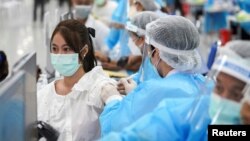 រូបឯកសារ៖ ស្ត្រី​ម្នាក់​ទទួល​វ៉ាក់សាំង​បង្ការ​ជំងឺ​កូវីដ១៩​របស់​ចិន Sinovac នៅ​មជ្ឈមណ្ឌល​ចាក់​វ៉ាក់សាំង ក្នុង​ទីក្រុង​បាងកក ប្រទេស​ថៃ ថ្ងៃទី២៤ ខែឧសភា ឆ្នាំ២០២១។ 