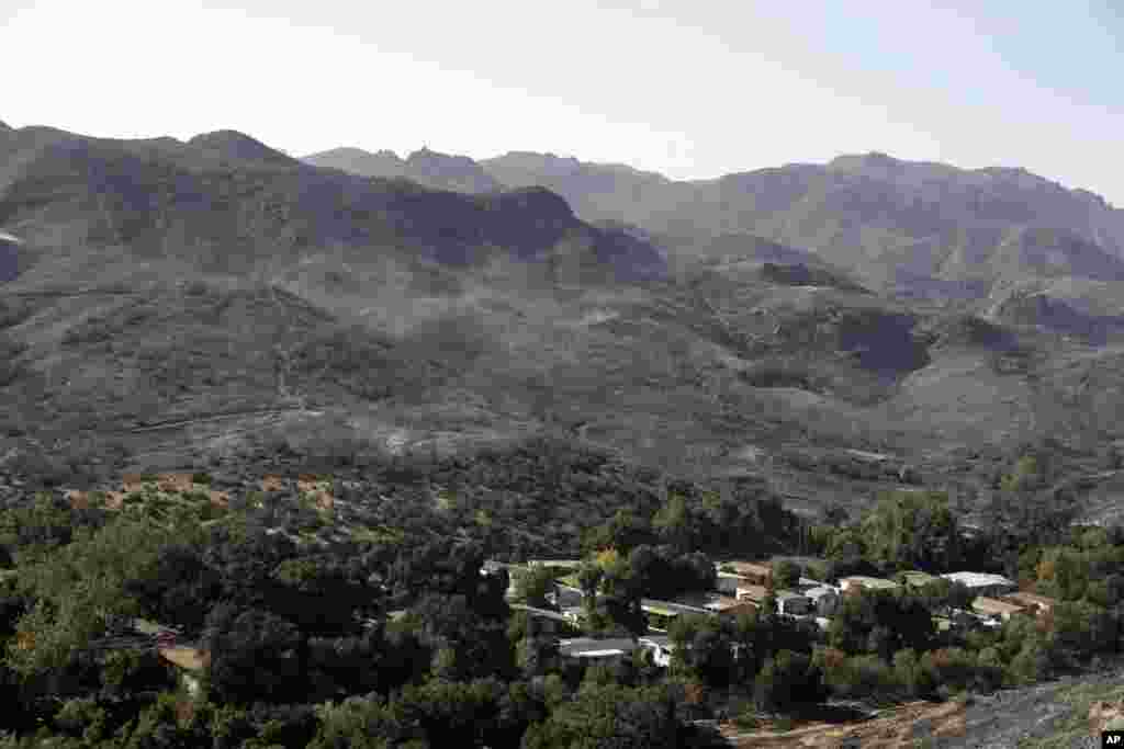 Burned down mountains tower over a residential neighborhood in the aftermath of a wildfire, Nov. 12, 2018, in Westlake Village, California.