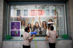 Trabajadoras limpian el escaparate de una tienda cuyos empleados se mantuvieron alejados del trabajo durante la protesta "Día sin mujeres", como parte de la escalada de protestas históricas contra la violencia de género, en la Ciudad de México.