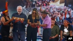 El presidente de Brasil, Luiz Inácio Lula da Silva, y su esposa Rosangela Silva, reciben regalos de líderes indígenas en el Centro Regional Lago Caracarana, en Normandía, en la reserva indígena Raposa-Serra do Sol, en el estado de Roraima, Brasil, el 13 de marzo de 2023.
