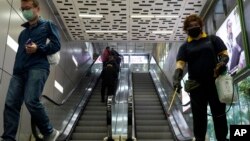 一名戴著口罩的香港工作人員正在噴灑消毒劑。（2020年3月17日）