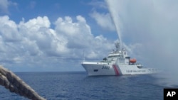 FILE - In this Sept. 23, 2015, file photo, Chinese Coast Guard members approach Filipino fishermen as they confront each other off Scarborough Shoal in the South China Sea, also called the West Philippine Sea. 