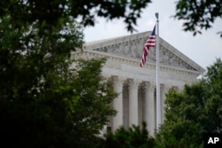 FILE - An American flag waves in front of the U.S. Supreme Court building, Monday, June 27, 2022, in Washington. (AP Photo/Patrick Semansky)