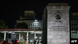 资料照：2022年6月17日，在日内瓦举行的世界贸易组织(WTO)第十二届部长级会议期间，代表团成员站在世贸组织总部的入口处。（法新社）