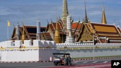 FILE - A motor-tricycle, or Tuk Tuk drives past Grand Palace in Bangkok, Thailand on Aug. 3, 2021. Thai authorities say that on July 1, 2022, they are lifting the need for arriving foreign visitors to register online to get pre-approval for entry.