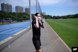Yoshimi Yamashita of Japan, takes off her protective mask during a training session, June 27, 2022, at JFA YUME Field in Chiba, near Tokyo.