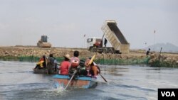 រូបឯកសារ៖ ប្រជាពលរដ្ឋជិះទូក​ទៅកាន់​កន្លែង​គ្រឿង​ចក្រ​កំពុង​ចាក់​ថ្ម​ចូល​បឹង​តាមោក ដែល​ចំ​កន្លែង​ពួកគេ​ចិញ្ចឹម​ត្រី ក្នុង​សង្កាត់​សំរោង​ត្បូង​ ​ខណ្ឌ​ព្រែក​ព្នៅ​ ​រាជ​ធានី​ភ្នំពេញ ថ្ងៃទី២៧ ខែមិថុនា ឆ្នាំ២០២២។ (ហាន ណូយ/វីអូអេ)