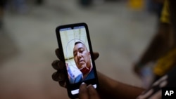 José Castillo, de 43 años, llegado de Nicaragua, demuestra cómo configurar un dispositivo portátil que le dieron las autoridades de inmigración mientras esperaba obtener transporte al aeropuerto de San Antonio en un almacén administrado por el grupo sin fines de lucro Mission: Border Hope, administrado por los Estados Unidos. Iglesia Metodista en Eagle Pass, Texas, 23 de mayo de 2022. (Foto AP/Dario López-Mills)