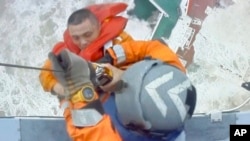 在香港政府飞行队发布的这张图片中，直升机机组人员在 2022年7月2日星期六在香港以南300公里的南中国海将一名正在沉没的船上吊起一名男子，当时台风“暹芭”正在该地区移动。香港救援机构周六表示，这艘在南海作业的工业支援船已经沉没，可能有超过20名船员丧生。