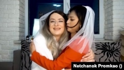 Netchanok "Love" Promkao and Dmytro "Jane" Denysov hug each other in a YouTube video clip, where they talk about their marriage situation