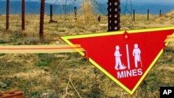巴格拉姆空軍基地雷場旁懸掛著國際地雷警告標誌。 （2002年3月22日）