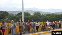 La gente cruza el Puente Internacional Simón Bolívar desde Cúcuta, Colombia, visto desde San Antonio del Táchira, Venezuela, el 4 de octubre de 2021.