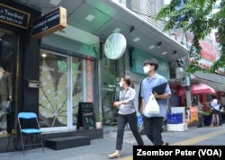 មនុស្សពីរនាក់ដើរកាត់ហាងលក់កញ្ឆា Chopaka ក្នុងទីក្រុងបាងកក ប្រទេសថៃ។