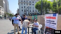 Ciudadanos recolectan firmas, el 19 de junio, en la plaza San Martín para presentar una demanda de inconstitucionalidad contra la ley aprobada en el Congreso sobre la reforma universitaria en Perú. [Foto: Rodrigo Chillitupa, VOA].