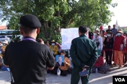 អាជ្ញាធរថតរូបប្រជាសហគមន៍សំរោងត្បូងរស់នៅជាប់បឹងតាមោក អង្គុយនៅទីធ្លាសួនវត្តបុទុមវត្តី ដែលឡើងមកដាក់លិខិតសុំអន្តរគមន៍អំពីរឿងទំនាស់ដីធ្លីរបស់ពួកគេ នៅខុទ្ទកាល័យនាយករដ្ឋមន្ត្រី ក្នុងរាជធានីភ្នំពេញ កាលពីថ្ងៃទី២៩ ខែមិថុនា ឆ្នាំ២០២២។ (លាស់ លីបលីប/វីអូអេ)