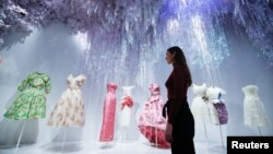 A gallery assistant poses for members of the media during a photocall for the "Christian Dior: Designer of Dreams" exhibition at the Victoria & Albert (V&A) Museum in London, Jan. 30, 2019. 