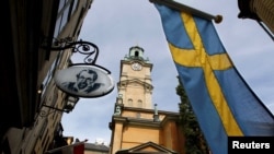 FILE - Sweden's flag is seen near the Stockholm Cathedral in Gamla Stan or the Old Town district of Stockholm, Sweden.