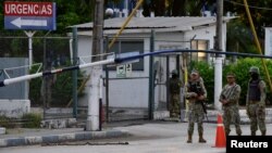 Custodios en la entrada principal del Hospital Naval en Guayaquil, donde fue llevado el exvicepresidente Jorge Glas el 8 de abril de 2024. Glas enfermó en una prisión tras su arresto durante una redada de la policía en la embajada de México en Quito.