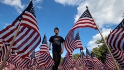 جاکسن تەکەر لە نێوان 3 هەزار ئاڵای ئەمەریکا لە یادی ئەو کەسانەی کە لە هێرشەکانی 11 ی سپتەمبەری 2001 گیانیان لەدەستدا، لە پارکی وینیتکا لە ویلایەتی ئیلنۆی. 10 ی مانگی 9 ی ساڵی 2016